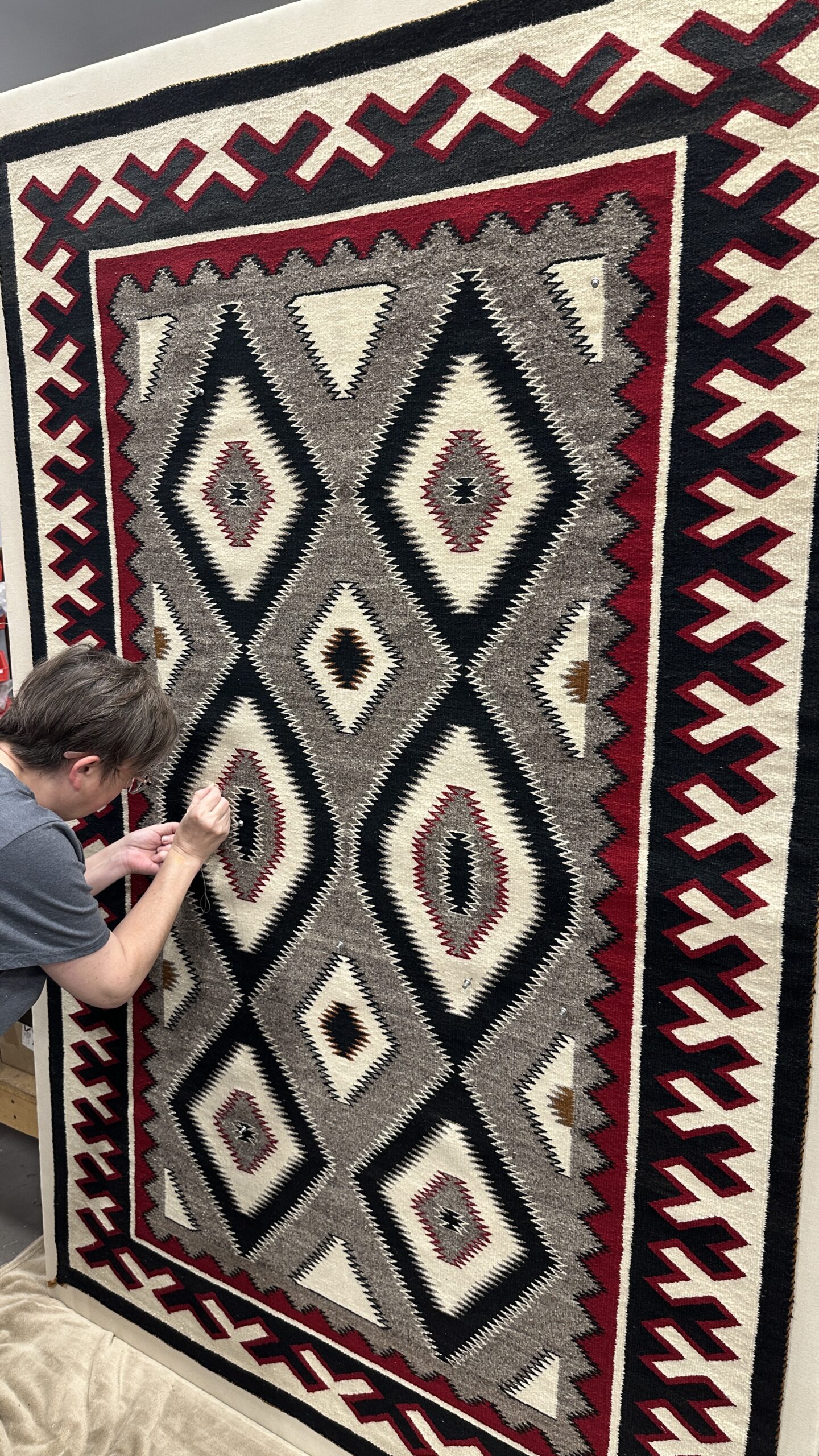 Hand stitching used to support textile work for framing